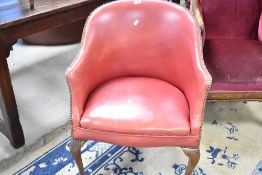 An early to mid 20th Century red leather and studwork tub armchair having cabriole legs