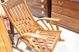 A modern teak steamer style rocking chair