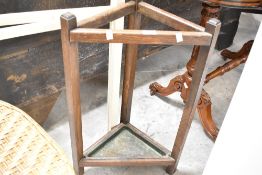 An early 20th Century oak triangular stick stand having metal drip tray