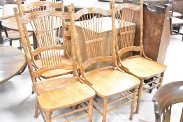 A set of four stained frame dining chairs in the colonial style having solid seats and spindle
