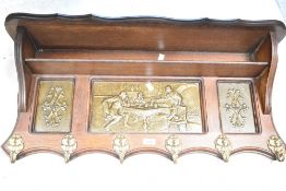 A reproduction oak wall shelf with coat hooks under having embossed inserts, width approx. 84cm