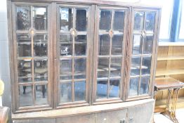 A late 19th or early 20th Century glazed bookcase in the Arts & Crafts style, with bow fronted