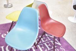 A set of four modern designer chairs, by Vitra after Eames, having dark maple legs, in mustard,