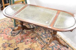 A reproduction Regency coffee table having oval top with green leather inset, approx. 106 x 45cm