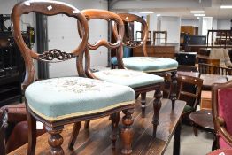 A harlequin set of three Victorian mahogany balloon back dining chairs having later tapestry seat on