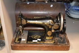 An early 20th-century cast iron body Singer hand crank sewing machine, having ornate gilt floral