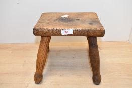 A late 19th century to early 20th-century elm milking stool, of small proportions, unmarked, 21cm in