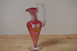 A small Victorian cranberry glass ewer, featuring white applied glass stringing to neck and a
