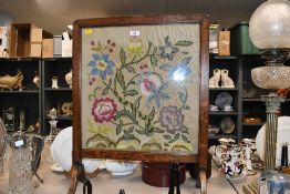 A fine early 20th-century floral crewelwork embroidery panel, set within a wooden-framed fire