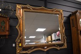 An unusual late 20th-century French-style imitation wood decorative wall mirror, featuring an ornate