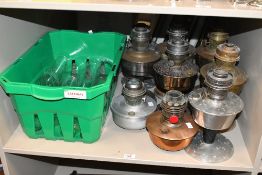 A collection of nine 20th-century Aladdin mantel oil lamps of varying metals, sold together with a