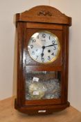 An early to mid-20th century German Kieninger oak wall-mounted clock, featuring a brass-rimmed metal