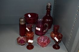 A selection of late 19th to early 20th-century cranberry glassware, to feature a small decanter with