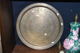 A large mid to late 20th-century Eastern brass charger, having engraved floral and scrollwork motifs