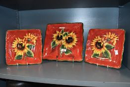 Three late 20th-century ceramic hand-painted sunflower decorated serving dishes, of square form,