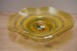 A large contemporary Ourglass studio art glass decorative bowl, having an organic form of swirled