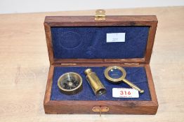 A vintage brass navigation set, to feature a telescope, compass and magnifying glass house in a