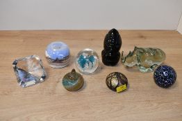 A selection of 20th-century studio art glass paperweights, to feature a light green glass rhinoceros