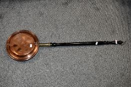A 19th-century copper bed warming pan, having a smooth turned wood handle, unmarked, approximately