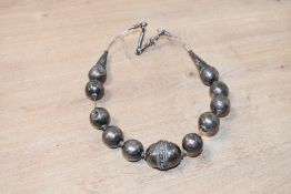 A late 19th to early 20th-century Omani white metal ball necklace, featuring hollow decorative