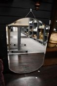A large early to mid 20th-century bevelled glass frameless mirror, upon a dark hard wood back,