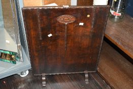 An early to mid 20th-century hard wood fireplace screen, featuring a carved oval floral