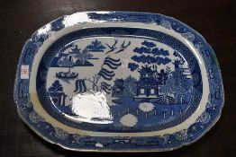 A large 19th-century willow-style blue and white ironstone charger, to feature an Oriental scene