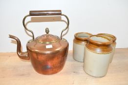 A late 19th-century copper and brass stove top kettle; sold with three stoneware storage jars, all