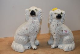 Two Victorian Staffordshire-style pottery spaniel mantel dogs, featuring a white glaze with gilt