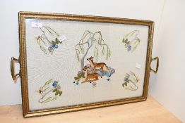 A sweet early 20th-century crewel work decorative tray, featuring a delicately rendered central deer