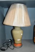 A tall contemporary studio pottery lamp base, of baluster form, featuring an olive green and rust