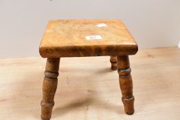 An early 20th-century wooden milking stool, of small proportions, unmarked, 19.5cm in height and
