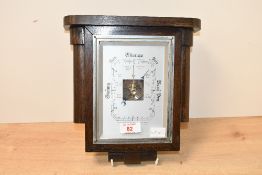 An early 20th-century Art Deco-style oak aneroid barometer, featuring a tapered case, unmarked but