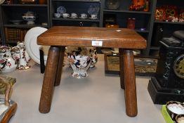 A vintage wooden stool, featuring a rectangular top with four thick tapered legs, unmarked, 32cm