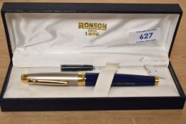 A boxed Ronson cartridge/ converter fill fountain pen in blue with brushed steel cap having gold