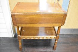 A mid-late 20th century oak drop-leaf trolley table, of traditional design with under shelf, lacking