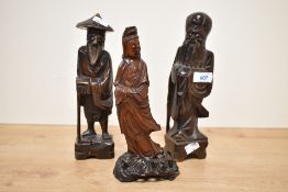 Three 20th-century Chinese carved hardwood figures, most likely of immortals, each dressed in