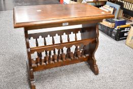 A sturdy mahogany occasional table magazine rack having decorative carved ends and turned spindles