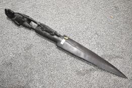 A vintage African Art hand carved dark wood wall decoration presumed male figure holding a paddle in