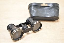 A pair of small 19th-century black metal opera glasses, having original black leather case, markings