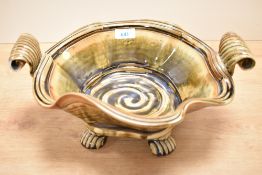 A 20th-century John Calver Studio pottery stoneware bowl, of a wavy organic shape with scrolled