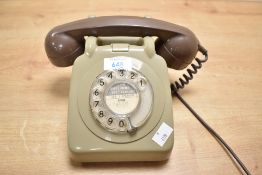 A vintage GPO 706F-style rotary telephone, featuring a green plastic body with a brown handset,