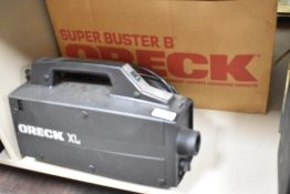 A vintage Oreck XL compact canister vacuum in original box.