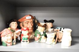 A large Royal Doulton Toby Jug-Blacksmith sold along with eight smaller similar Toby Jugs.