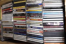 A box of mixed compact discs including country, pop and more.