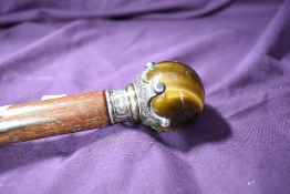 A walking cane measuring 100cm long with a smokey glass ball of 4cm diameter in a white metal