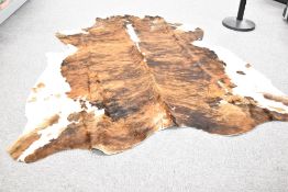 A large cow hide measuring 190cm x 200cm some splits and holes along the spine