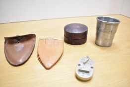 A double sided silver metal game counter, a cased collapsible cup and a leather cup/drinking