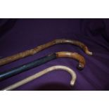 Three wooden walking sticks with bent wood handles measuring 74cm 82cm and 110cm