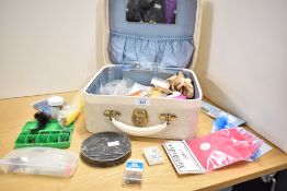 A small vanity case containing fly tying materials and a vintage cast tin
